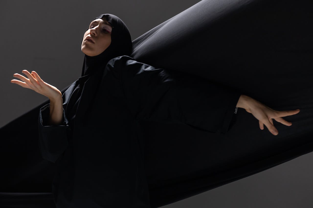Elegant studio portrait of a woman wearing a hijab striking a graceful pose.