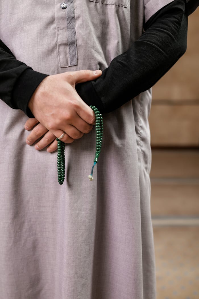 Close-up of a person holding Islamic prayer beads, reflecting cultural tradition.